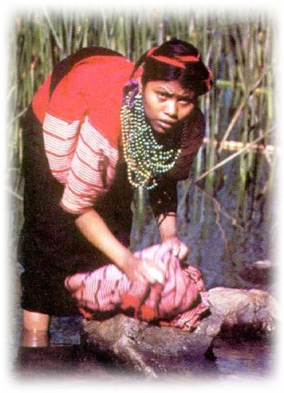 Woman washing clothes on lake shore, san antonio palopo